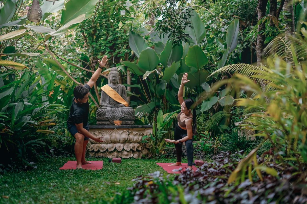 Ubud Nyuh Bali Resort & Spa Exterior foto A yoga teacher training a student in Bali, Indonesia